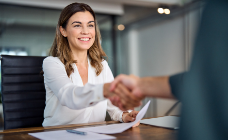 woman giving a handshake at a desk